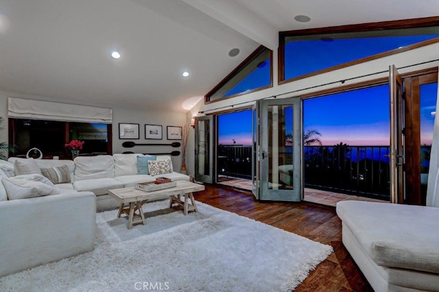 living room featuring dark wood-type flooring and vaulted ceiling with beams