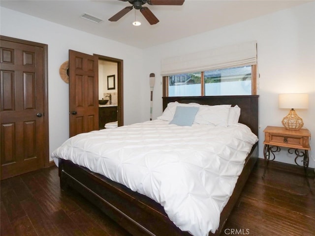 bedroom with dark wood-type flooring, ceiling fan, and ensuite bathroom