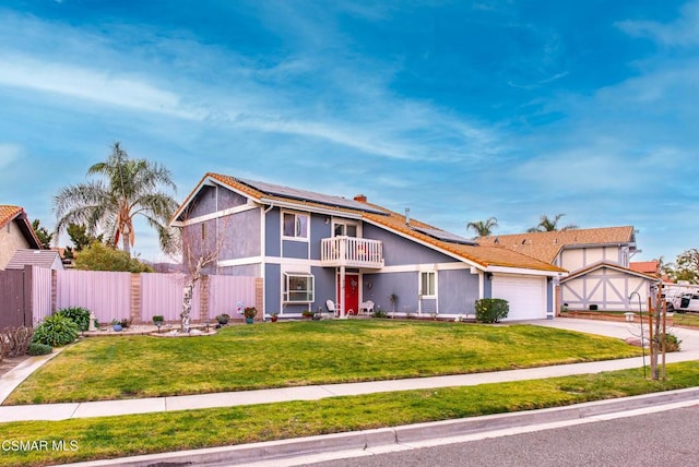 view of front of house featuring a garage, a balcony, a front yard, and solar panels