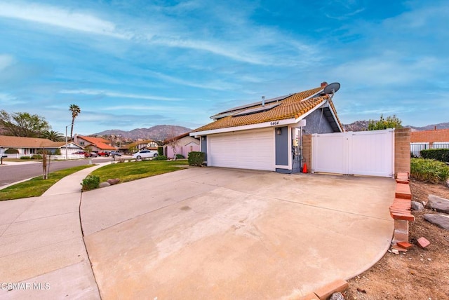 view of property exterior with a mountain view and solar panels