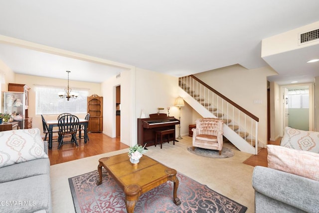 living room featuring a healthy amount of sunlight, a chandelier, and light hardwood / wood-style flooring