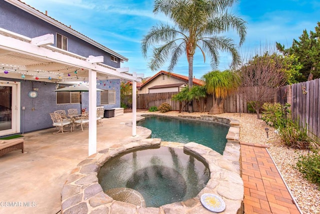 view of pool with a patio and an in ground hot tub