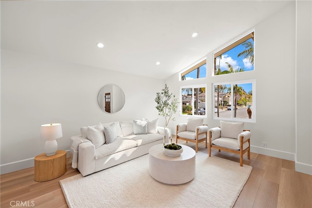 living room featuring vaulted ceiling and light wood-type flooring