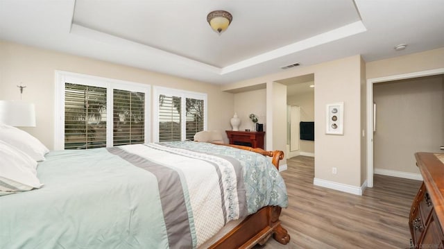 bedroom featuring a tray ceiling and hardwood / wood-style flooring