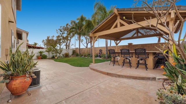 view of patio with a gazebo, central air condition unit, and a bar