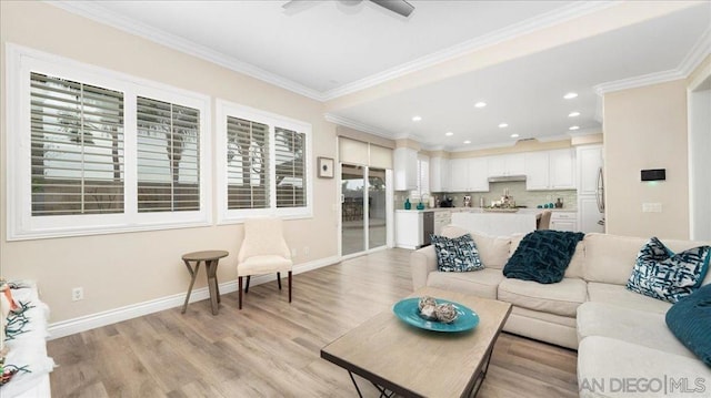 living room featuring a healthy amount of sunlight, ornamental molding, ceiling fan, and light wood-type flooring