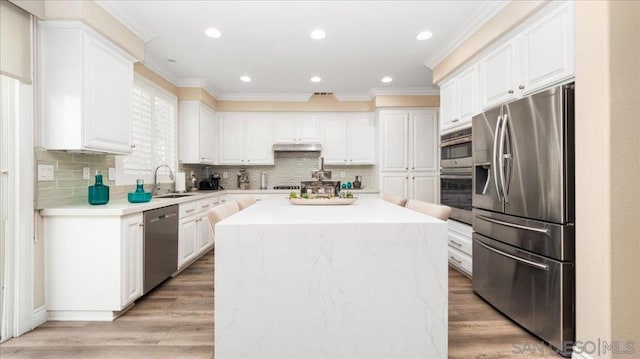 kitchen featuring white cabinetry, sink, stainless steel appliances, and a center island