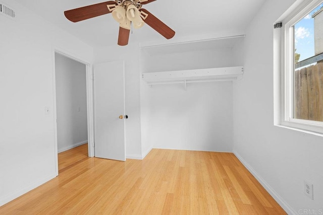 unfurnished bedroom with ceiling fan, wood-type flooring, and a closet