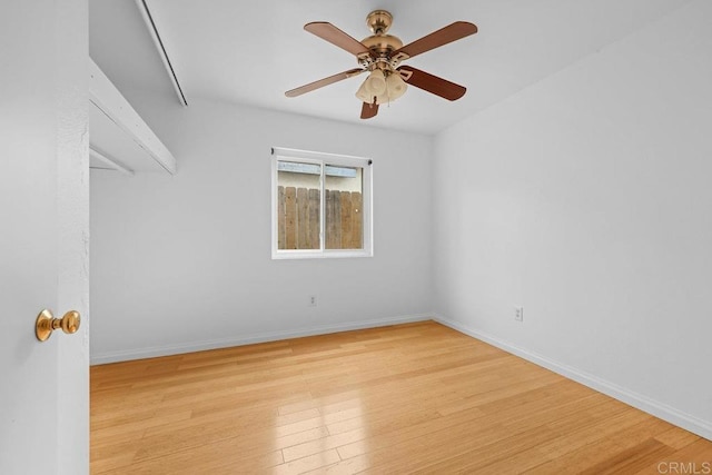 empty room with ceiling fan and light hardwood / wood-style flooring