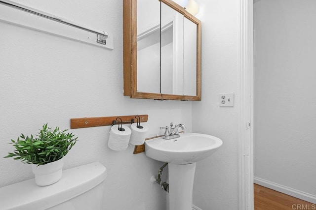 bathroom featuring hardwood / wood-style flooring and toilet