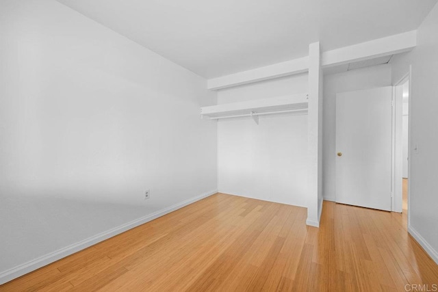 unfurnished bedroom featuring light hardwood / wood-style floors and a closet