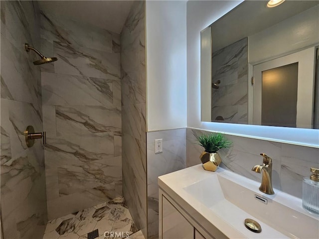 bathroom with vanity, tile walls, and tiled shower