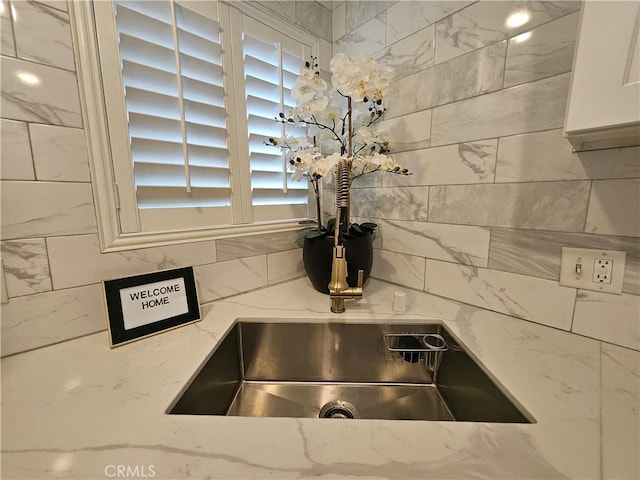 interior details featuring white cabinetry and light stone counters