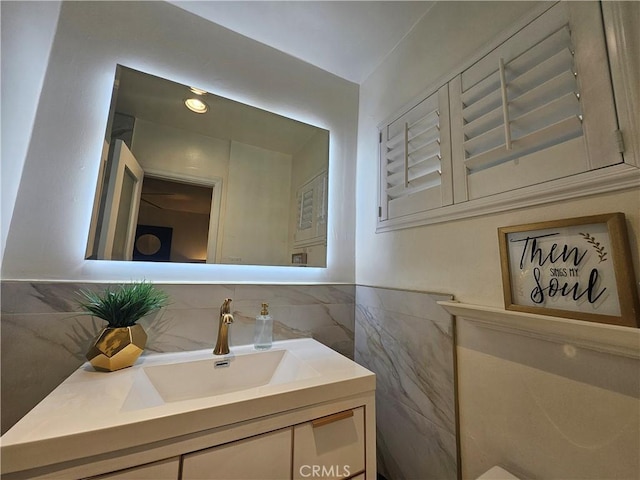 bathroom featuring vanity and tile walls