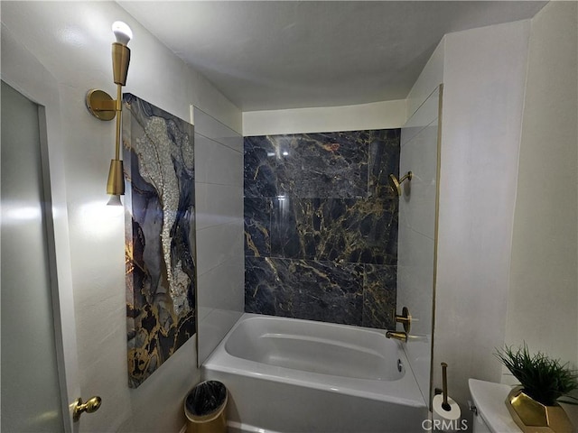 bathroom featuring tiled shower / bath and toilet