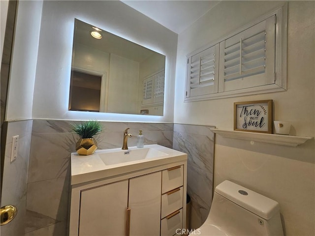 bathroom featuring vanity, toilet, and tile walls