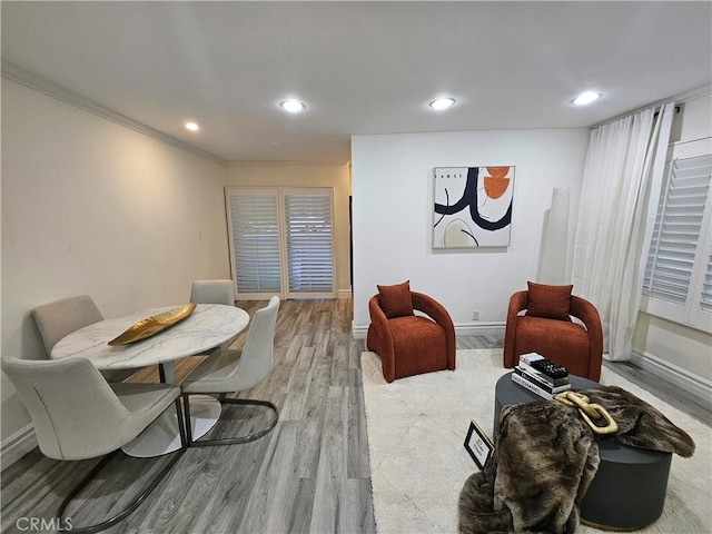 living room with wood-type flooring and crown molding