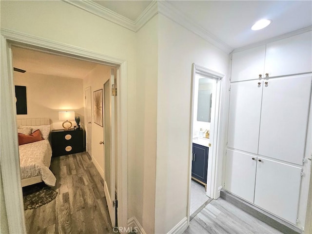 hallway featuring ornamental molding and light wood-type flooring