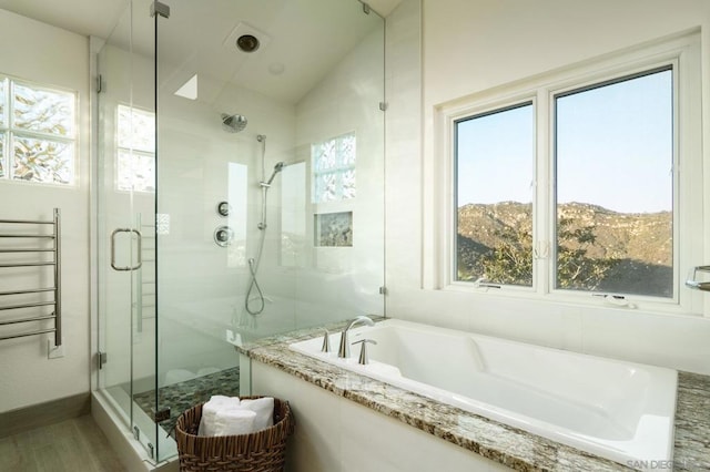 bathroom featuring vaulted ceiling, shower with separate bathtub, a mountain view, and radiator