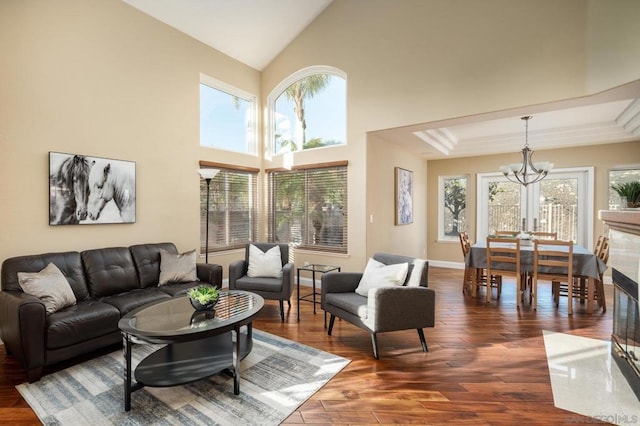 living room with dark hardwood / wood-style floors, a notable chandelier, and high vaulted ceiling