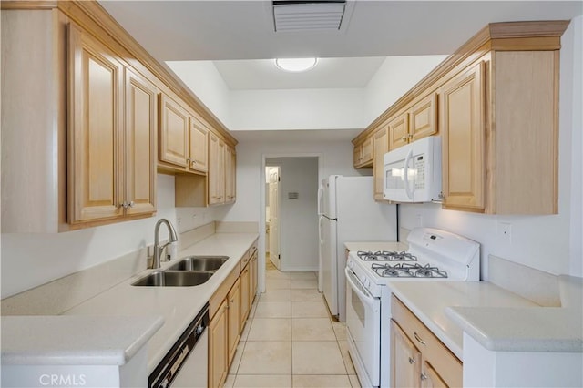 kitchen with light tile patterned flooring, sink, light brown cabinetry, and white appliances