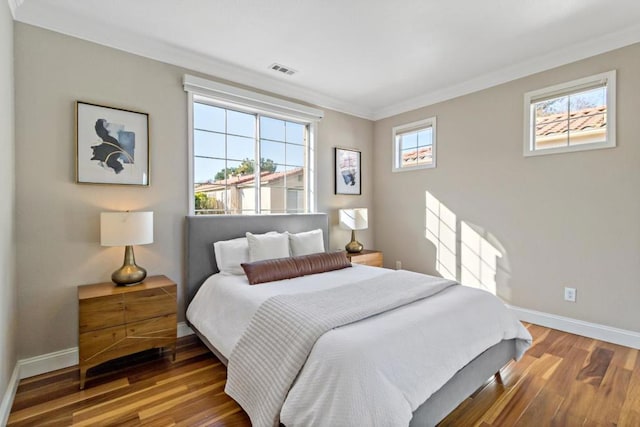 bedroom with wood-type flooring and ornamental molding