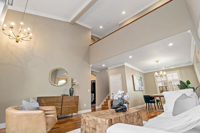 living room featuring hardwood / wood-style flooring, crown molding, a high ceiling, and a notable chandelier