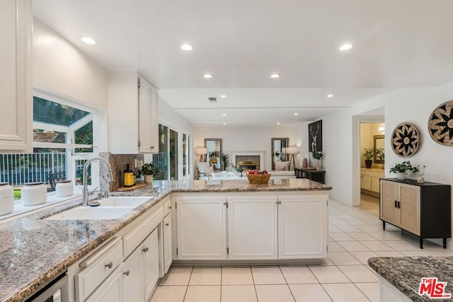 kitchen with sink, white cabinets, and kitchen peninsula