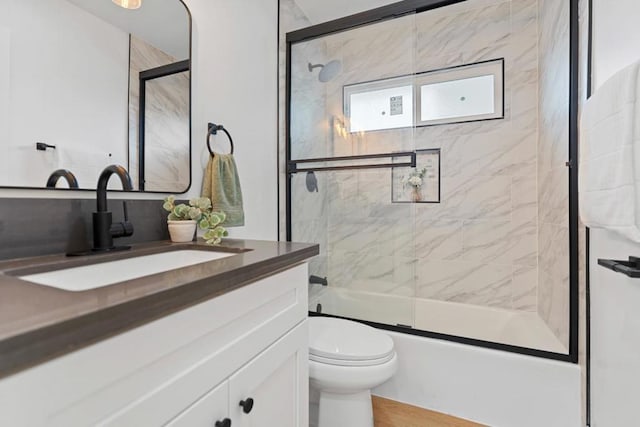 full bathroom with vanity, toilet, and combined bath / shower with glass door