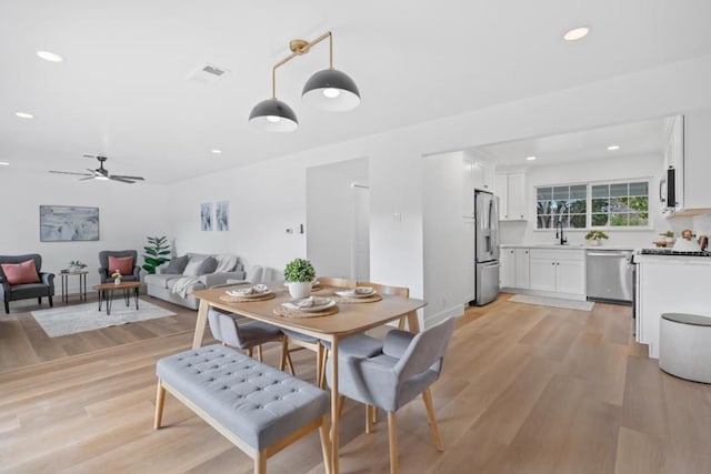 dining area with ceiling fan and light wood-type flooring