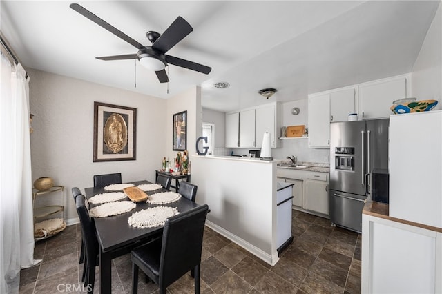 dining space featuring sink and ceiling fan