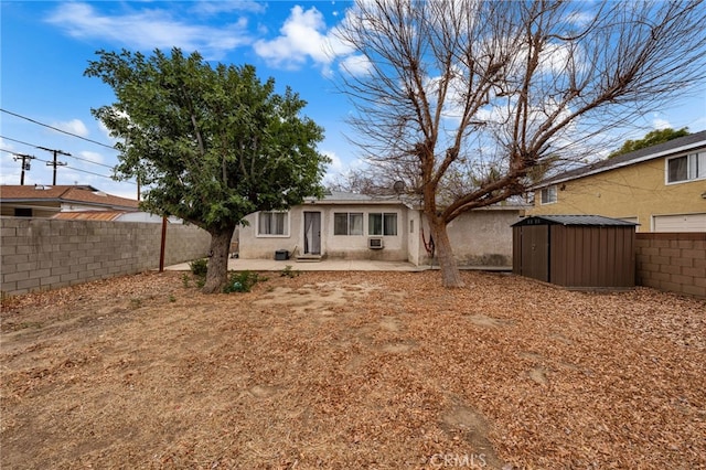 rear view of house with a patio and a storage unit