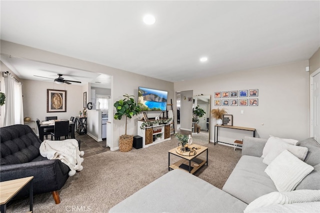 living room featuring dark colored carpet and ceiling fan