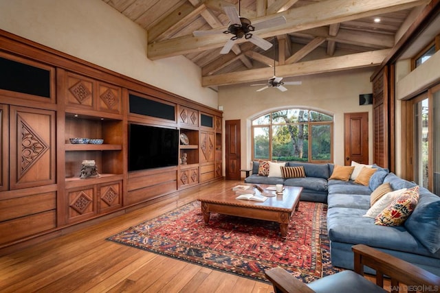 living room featuring wood-type flooring, plenty of natural light, and high vaulted ceiling