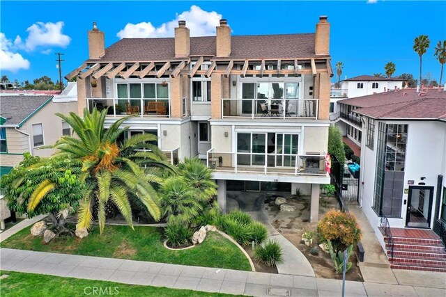 back of house featuring a carport and a balcony