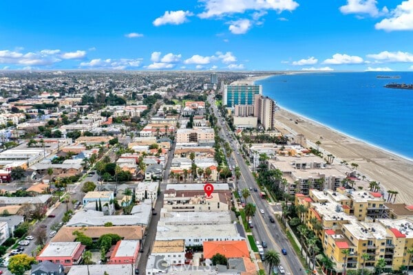 aerial view with a water view, a view of city, and a beach view