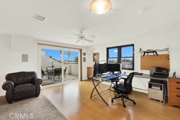 home office with ceiling fan and light hardwood / wood-style floors