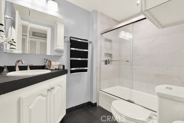 bathroom with vanity, tile patterned floors, toilet, and baseboards