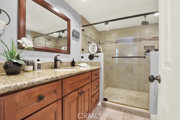 bathroom featuring vanity, an enclosed shower, and tile patterned flooring