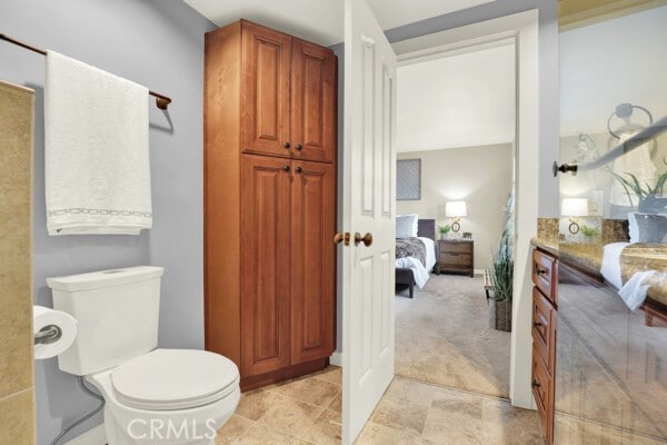 ensuite bathroom featuring toilet and connected bathroom