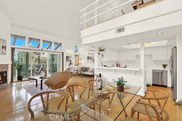 living room with a towering ceiling and light wood-type flooring