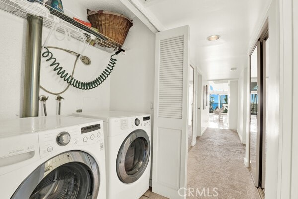 washroom with separate washer and dryer and light colored carpet