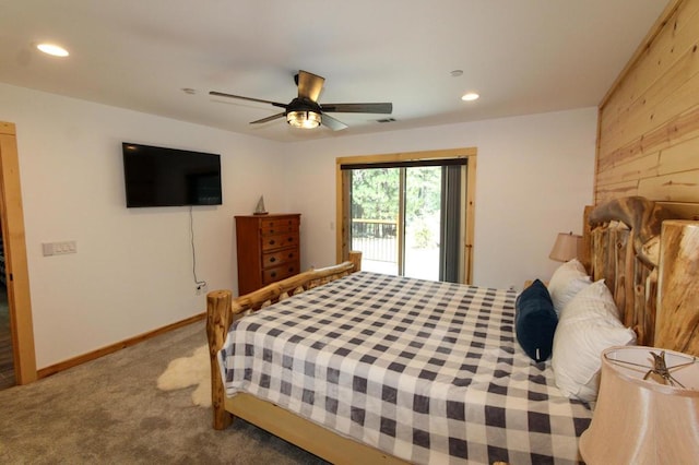 bedroom featuring wooden walls, carpet floors, access to outside, and ceiling fan