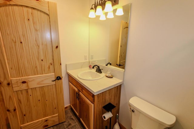 bathroom featuring vanity, a chandelier, and toilet