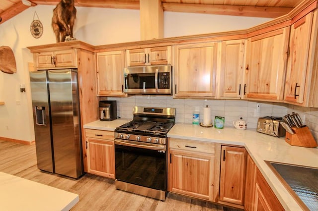 kitchen featuring vaulted ceiling with beams, sink, backsplash, stainless steel appliances, and light hardwood / wood-style flooring