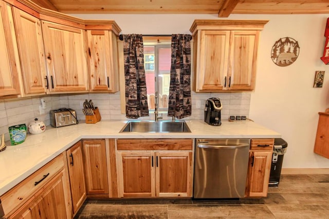 kitchen featuring tasteful backsplash, sink, hardwood / wood-style flooring, and dishwasher