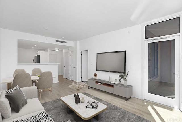 living room featuring visible vents and light wood-style flooring