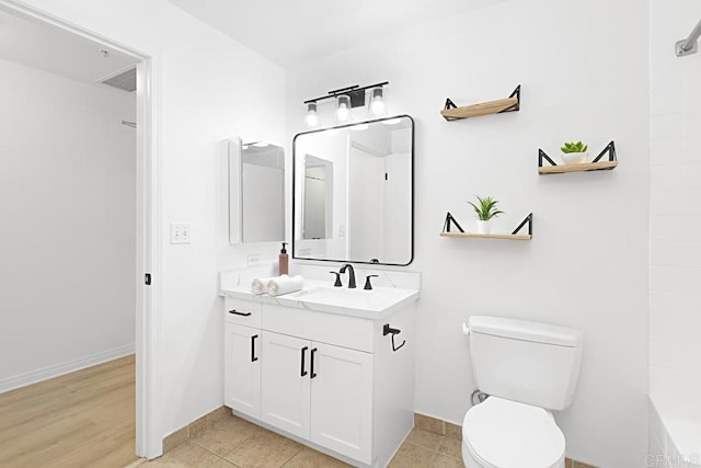 bathroom with baseboards, visible vents, toilet, tile patterned flooring, and vanity