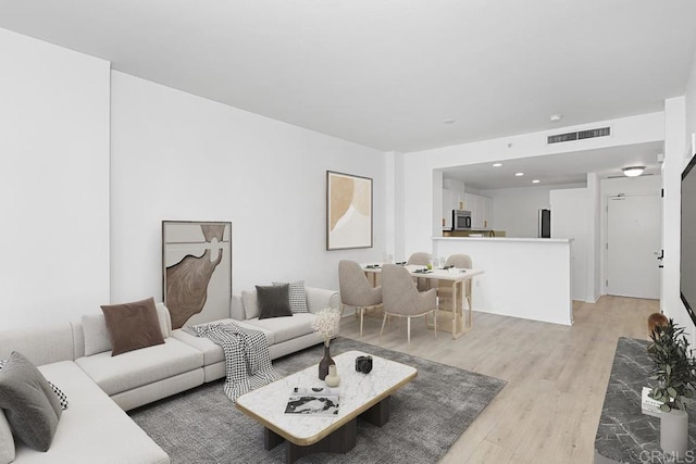 living area with visible vents and light wood-style floors