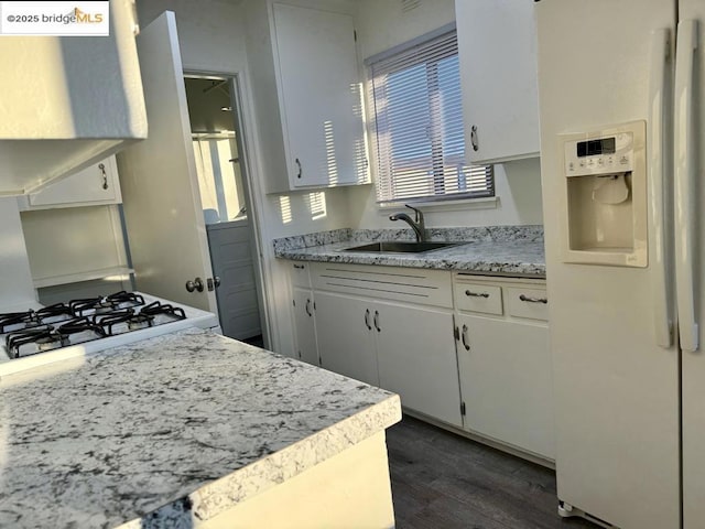 kitchen featuring white fridge with ice dispenser, sink, white cabinets, and dark hardwood / wood-style floors